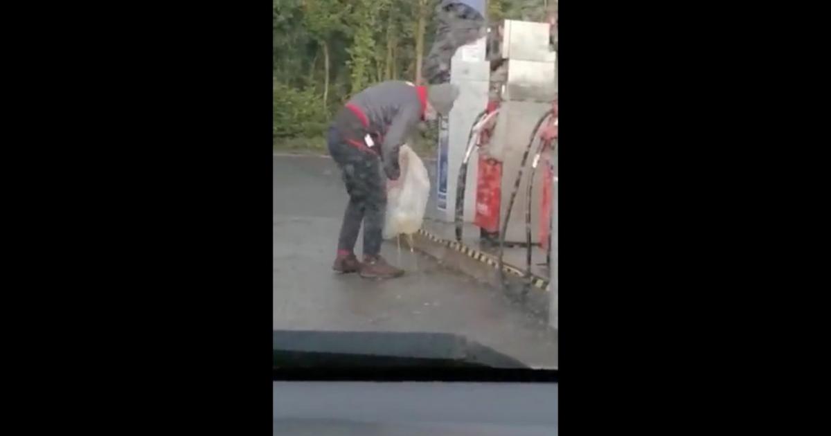 Facet na stacji benzynowej próbuje zabrać benzynę w plastikową torbę